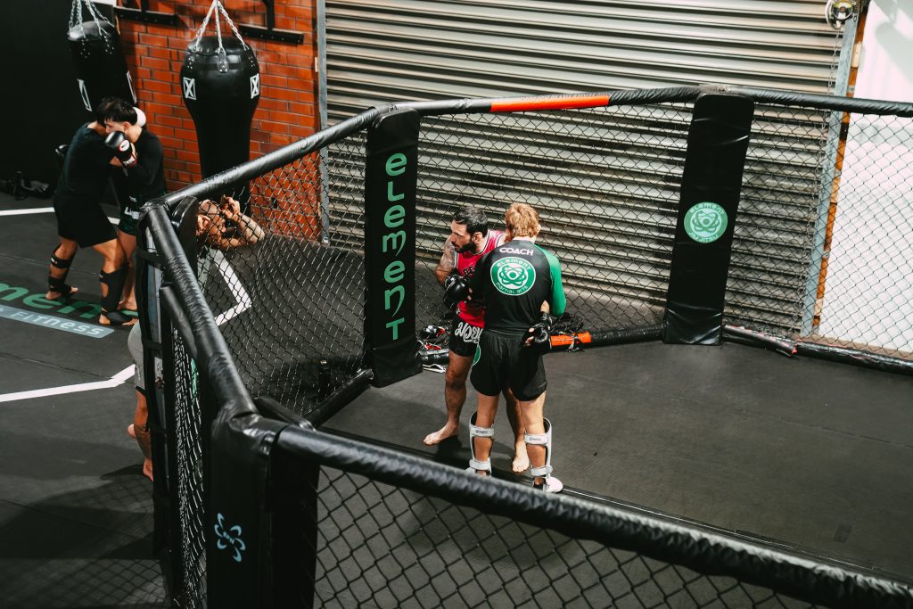 Element Martial Arts coaches training together in a cage 